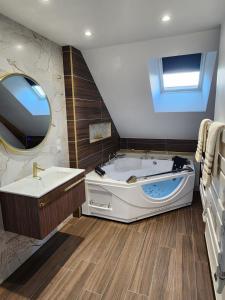 La grande salle de bains est pourvue d'une baignoire et d'une télévision. dans l'établissement Le coq'oon de challes, à Challes