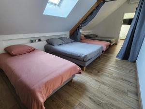 trois lits dans une chambre avec des rideaux bleus dans l'établissement Le coq'oon de challes, à Challes