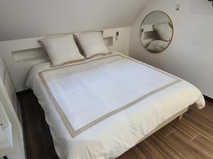 une chambre avec un lit blanc avec un miroir dans l'établissement Le coq'oon de challes, à Challes