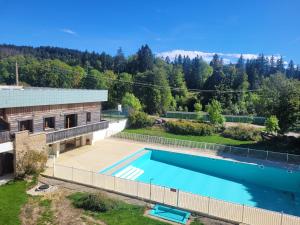 einen Blick über einen Pool neben einem Gebäude in der Unterkunft Au petit montagnard in Les Rousses