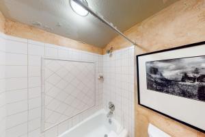 een badkamer met een schilderij aan de muur en een bad bij Creekside East 1 in Mid Vail +15 foto's