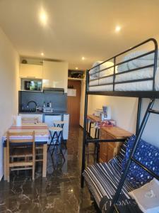 Zimmer mit Etagenbett und Küche in der Unterkunft Au petit montagnard in Les Rousses