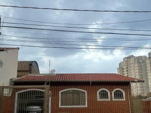 un edificio rosso con un tetto rosso e linee elettriche di Hospedagem somente para mulheres a Botucatu