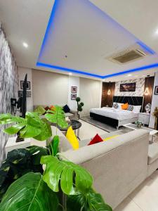 a living room with a couch and some plants at Luxurious One-Bedroom Gold Crest Apartment with Stunning Balcony Retreat DHA Lahore in Lahore