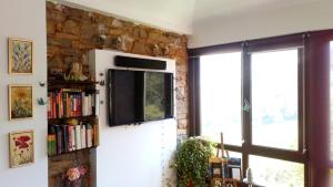 a living room with a tv on a stone wall at Mirador de Proacina - Senda del Oso 
