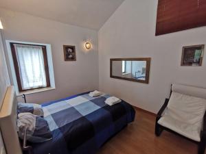 a bedroom with a bed and a chair and a mirror at Mirador de Proacina - Senda del Oso 