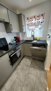 eine Küche mit Spüle und Herd in der Unterkunft Cosy 1 bedroom apartment near Woodstock and Oxford in Kidlington