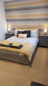 ein großes Bett in einem Zimmer mit zwei Nachttischen in der Unterkunft Cosy 1 bedroom apartment near Woodstock and Oxford in Kidlington