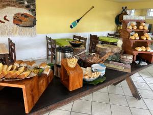 a buffet with bread and other food on a table at Costamar Pousada e Restaurante in Una