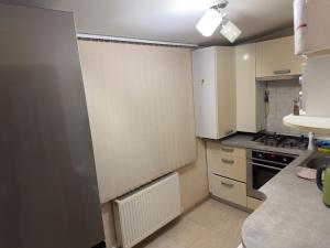 a kitchen with white cabinets and a stove top oven at Simple and accessible in Durleşti