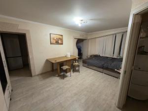 a room with a bed and a desk and a table at Simple and accessible in Durleşti