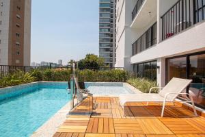 a swimming pool on a balcony with a chair next to a building at Perdizes Smart Experience - Ao lado do Allianz Parque in Sao Paulo