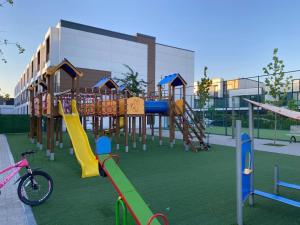 a playground with colorful slides and a bike on the grass at Apartament Chișinău Arena in Chişinău