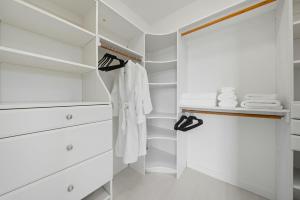 a white walk in closet with white clothes and shoes at Book the Entire Eleanor Inn in Walla Walla +87 photos