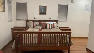 a bedroom with a wooden bed with pillows at R and R Hideaway Suite in Fairbanks
