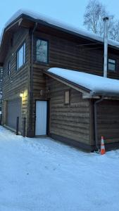 a log cabin with snow on the side of it at R and R Hideaway Suite in Hamilton Acres