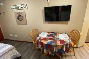 Habitación con mesa con sillas y TV. en Coffee studio, walking distance to downtown, en Slaterville