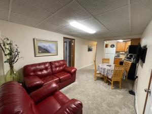 a living room with a leather couch and a table at Moose 2 bedroom lower, close to downtown in Fairbanks +5 photos