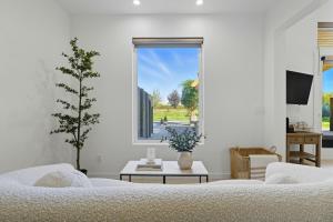 Una sala de estar con un sofá blanco y una ventana. en Eleanor Suite, en Walla Walla