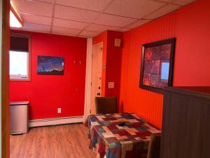 ein Zimmer mit roten Wänden, einem Tisch und Stühlen in der Unterkunft Colorful Studio, near downtown, walk to shopping in Slaterville