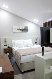 ein Hotelzimmer mit einem Bett und einem TV in der Unterkunft Casa Bianca Hotel in Denizli