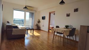 una sala de estar con una mesa y un sofá en Sunny Panorama Apartment, en Skopje