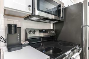 eine kleine Küche mit Herd und Mikrowelle in der Unterkunft Walk to Atrium Peaceful Downtown Stay in Macon