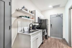 eine weiße Küche mit Spüle und Kühlschrank in der Unterkunft Walk to Atrium Peaceful Downtown Stay in Macon + 4 Fotos