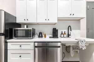 eine Küche mit weißen Schränken und einer Mikrowelle in der Unterkunft Accessible Comfort Near Atrium & Downtown Macon in Macon
