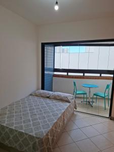 a bedroom with a bed and a table and chairs at Ap Orla de Aracaju in Aracaju