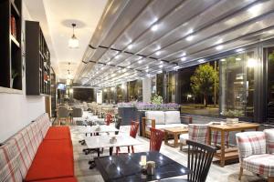 a restaurant with tables and chairs and windows at Casa Bianca Hotel in Denizli