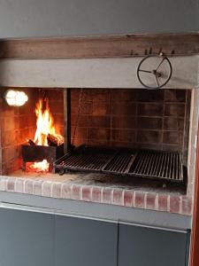 a brick fireplace with a fire in it at Casa Waikiki in Mar del Plata