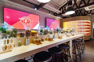 キルケニーにあるThe Tholsel Bar and Townhouse Kilkennyの植物のある部屋のスツール付きのバー