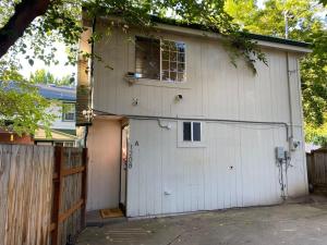 a white garage with a window and a fence at Near Downtown- Kitchen-washerdryer-parking in Medford
