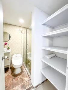 une salle de bain blanche avec toilettes et douche dans l'établissement Azul Caribe 104, à Coveñas