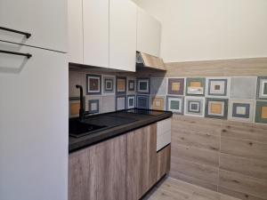 a kitchen with white cabinets and a black counter top at marte rooms in Centola