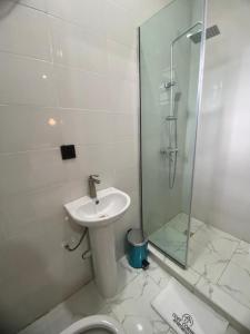 a bathroom with a sink and a shower and a toilet at Cozy Corner Apartments in Lekki