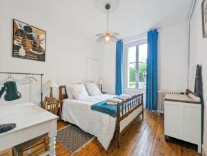 Schlafzimmer mit einem Bett mit blauen Vorhängen in der Unterkunft Grande maison familiale de charme Vic-Sur-Cère 9ch in Vic-sur-Cère