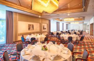 a large banquet room with tables and chairs at Leonardo Hotel Karlsruhe in Karlsruhe