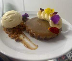 a white plate with a dessert with ice cream on it at The castle inn in Boston