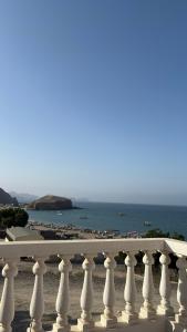 a white fence with a beach in the background at Qantab village apartment in Muscat