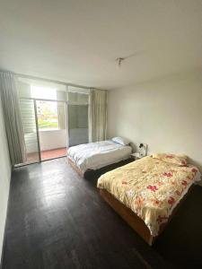 a bedroom with two beds and a large window at B&B Villamar Chorrillos in San Antonio