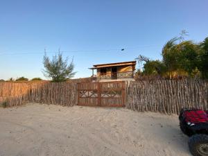 a fence with a gate in front of a house at Casa Nativa Tatajuba in Camocim +3 photos