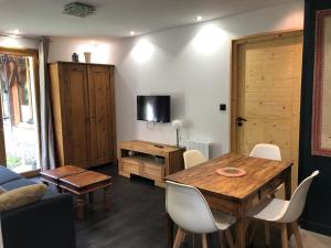 a living room with a wooden table and a tv at Gîtes du Grand Replomb in Sainte-Agnès