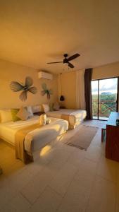 ein Schlafzimmer mit zwei Betten und einem großen Fenster in der Unterkunft sunsteps casa holbox in Holbox