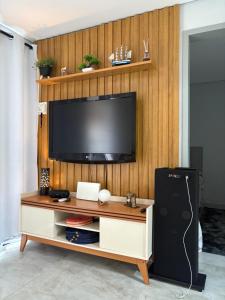 a television on a wooden wall in a living room at Casa Malu in Bertioga