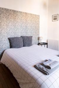 una camera da letto con un letto bianco con due asciugamani sopra di Les Jardins de La Cité 60m2 et parking gratuit a Digione Altre 8 foto