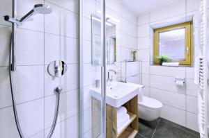a white bathroom with a sink and a shower at Wiesenhäusl in Bischofswiesen +31 photos