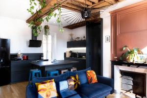 un soggiorno con un divano blu e un camino di Les Jardins de La Cité 60m2 et parking gratuit a Digione