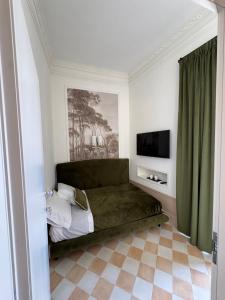 a bedroom with a green bed and a television at Gradini dell arte in Naples